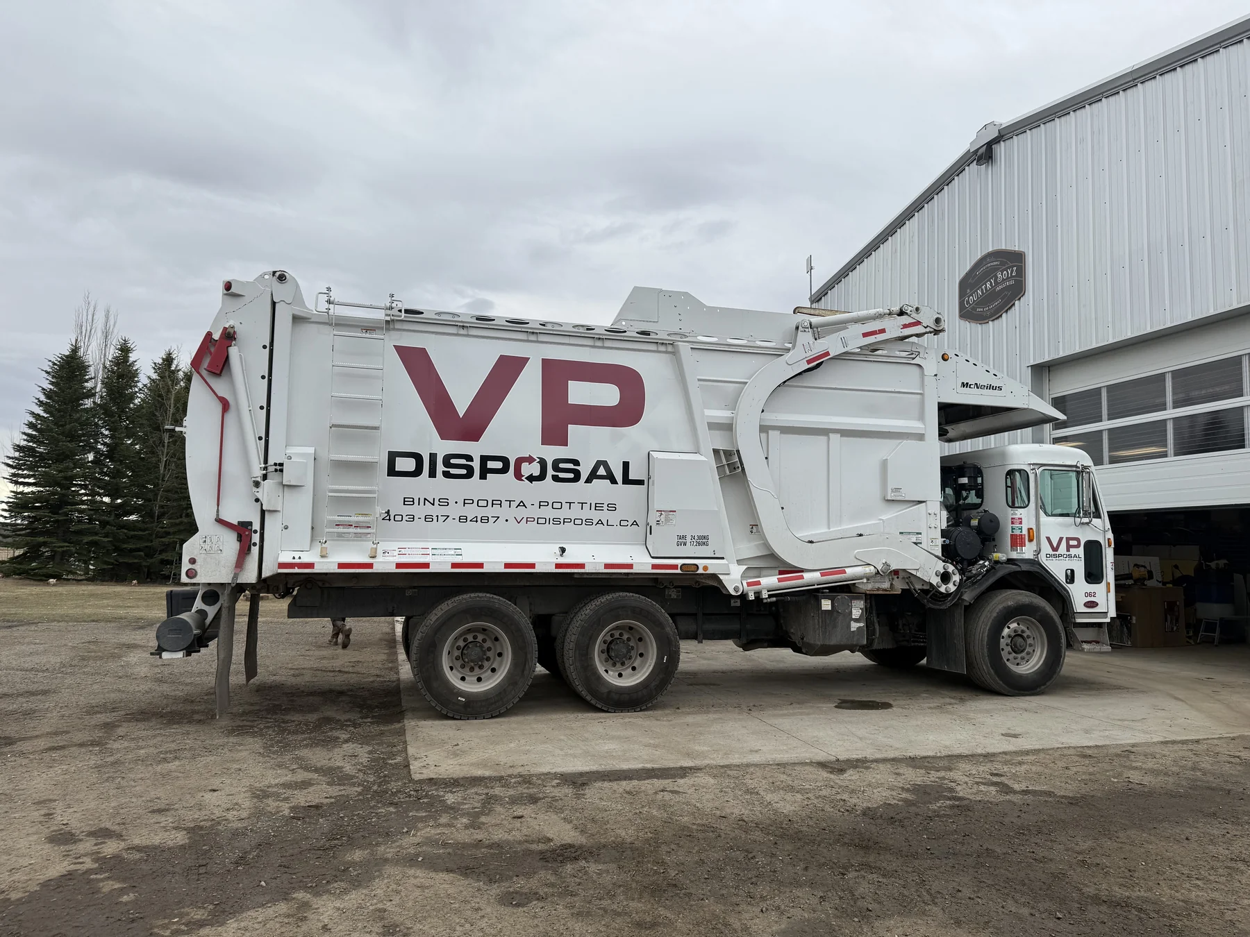 VP Disposal front-load collection truck beside the yard building