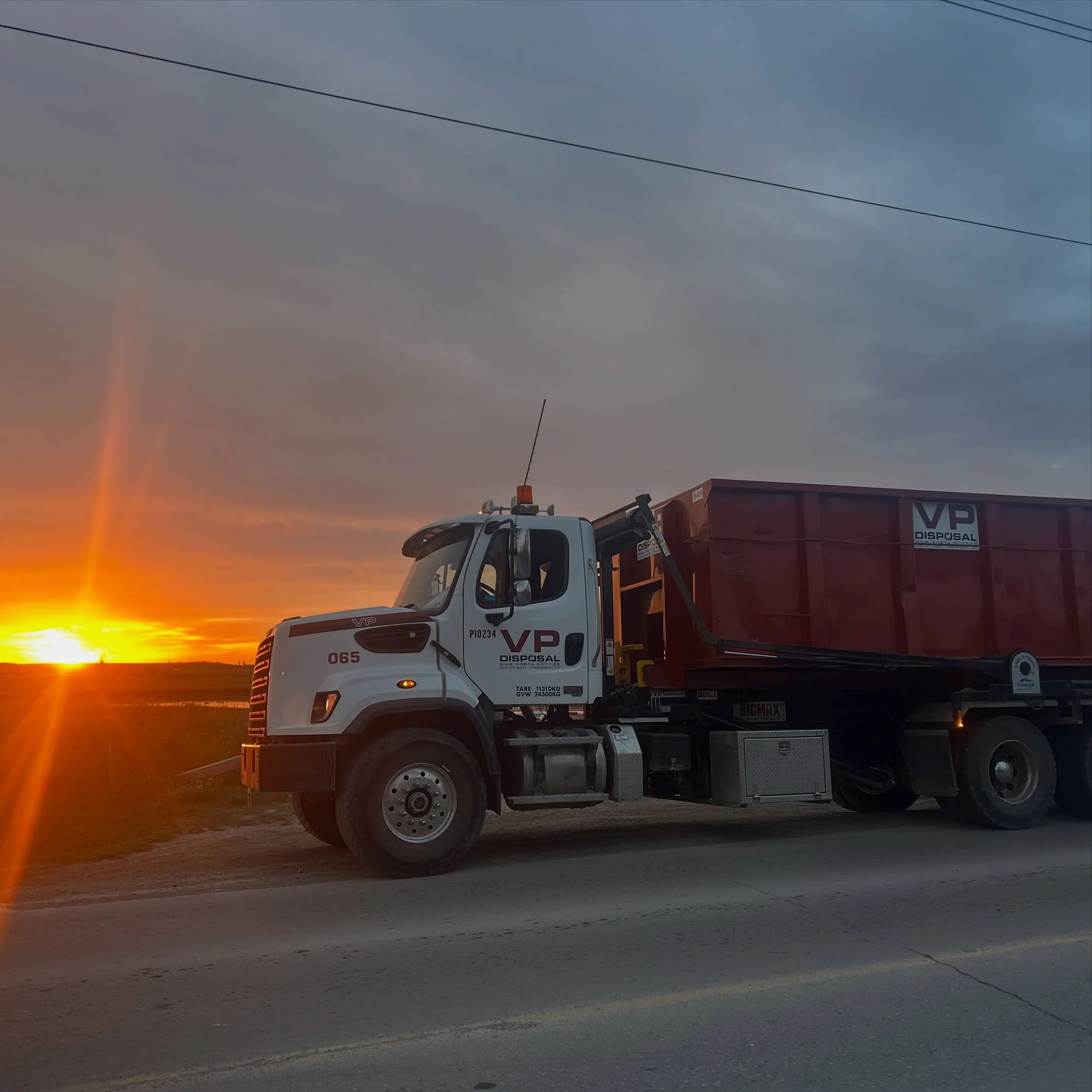 VP Disposal Unit 65 truck with the sunset behind it